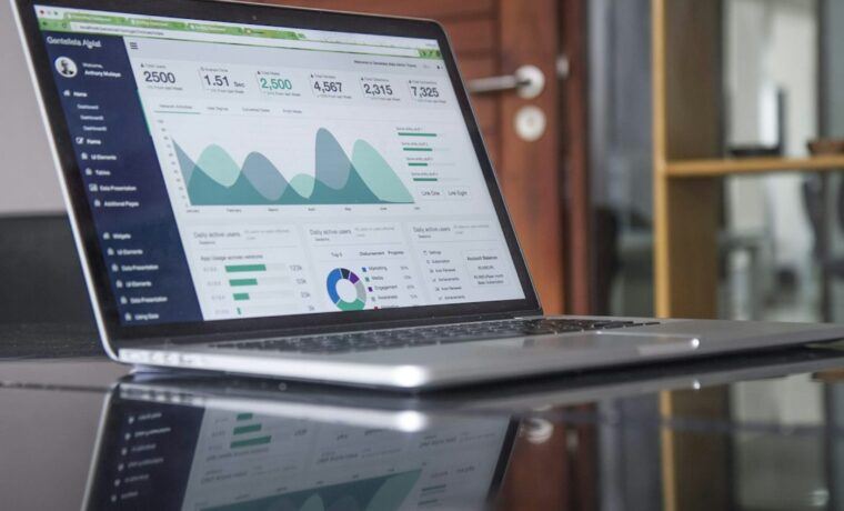 Laptop showing website analytics beside a notebook used to plan an SEO budget