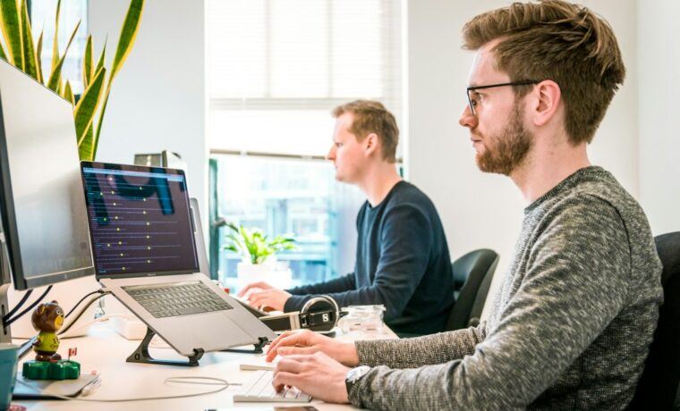 Web development team working together on laptops in an office