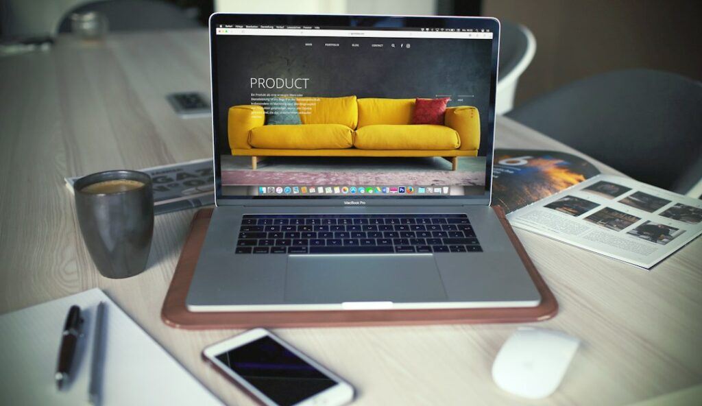 Laptop displaying an online store product page next to a shopping bag