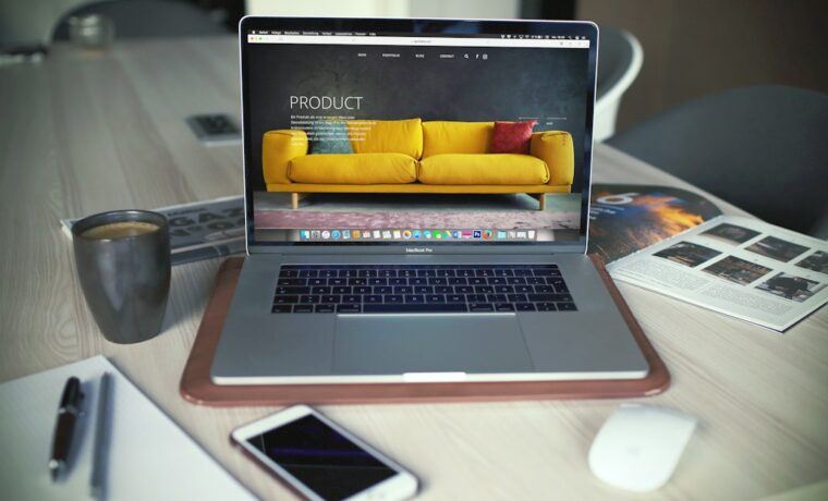 Laptop displaying an online store product page next to a shopping bag